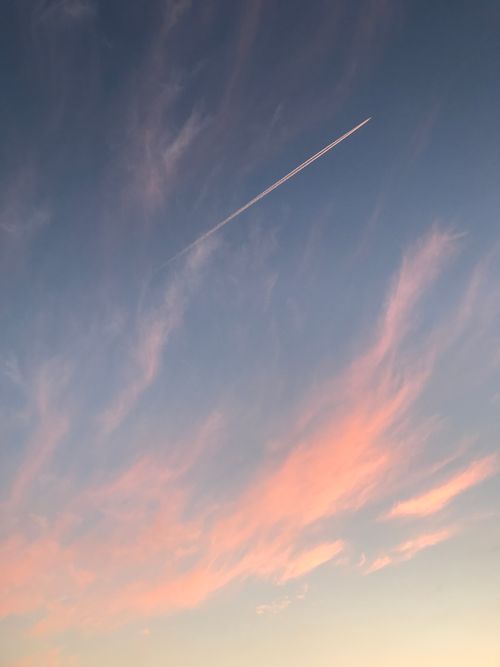 Free A beautiful sky at sunset with pink clouds and an airplane contrail over London. Stock Photo