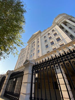 A striking low-angle view of a classic residential building with ornate gates in Chișinău, Moldova, under a clear blue sky.