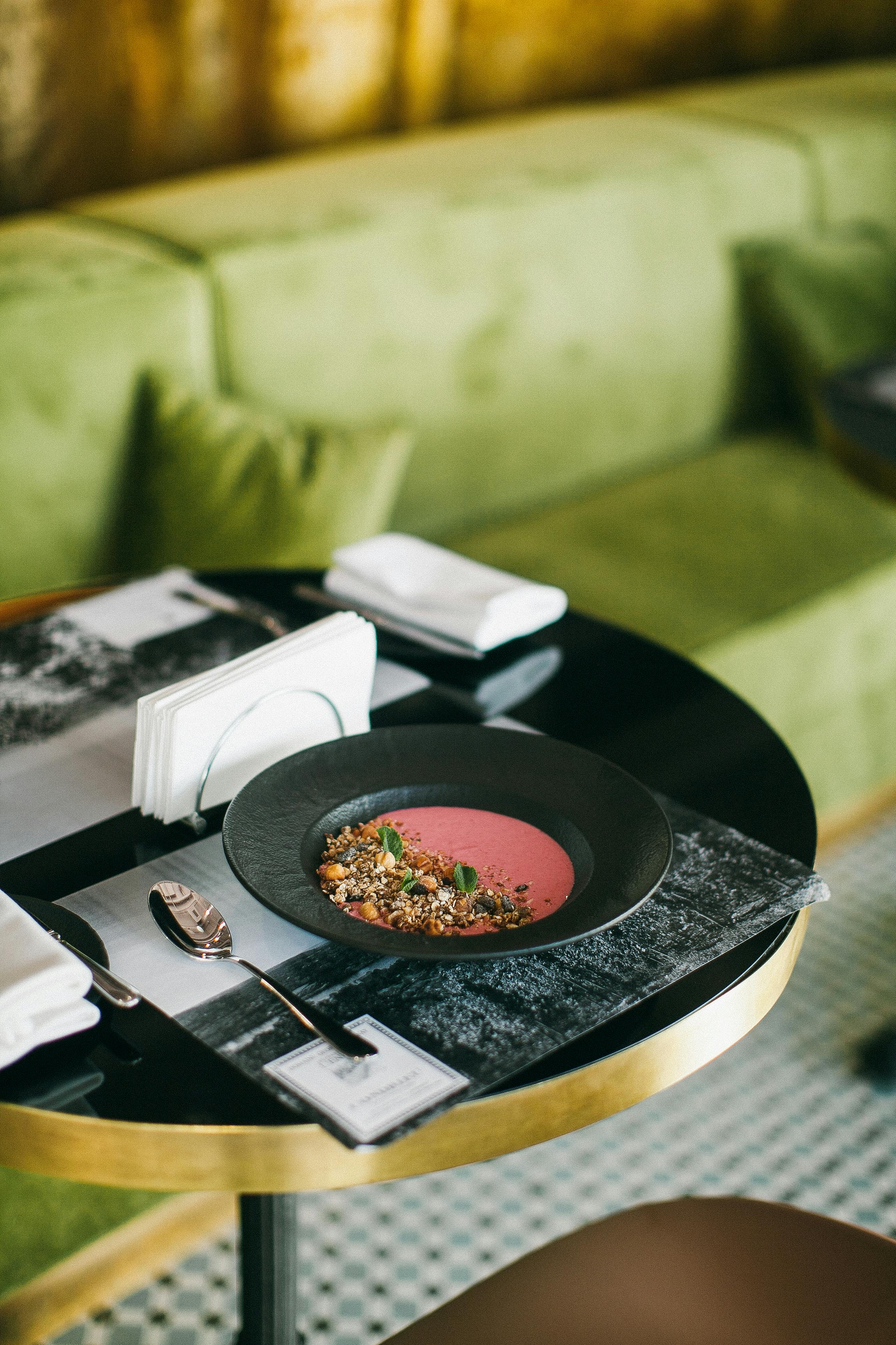 Plate of Food Beside Silver Spoon on Black Wooden Table