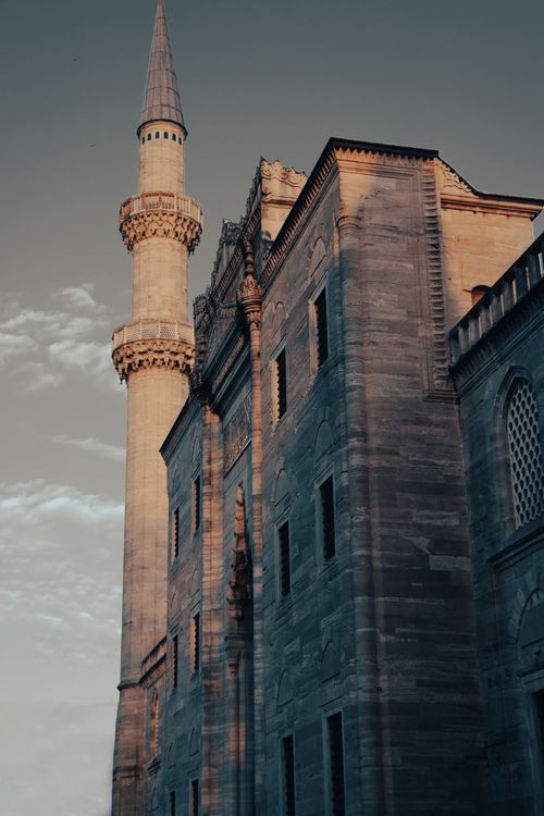 Free Beautiful view of a historic mosque's minaret against a sunset sky, highlighting Islamic architecture. Stock Photo