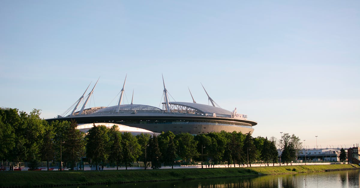 Scenic view of Gazprom Arena beside a tranquil river in Saint Petersburg, Russia.