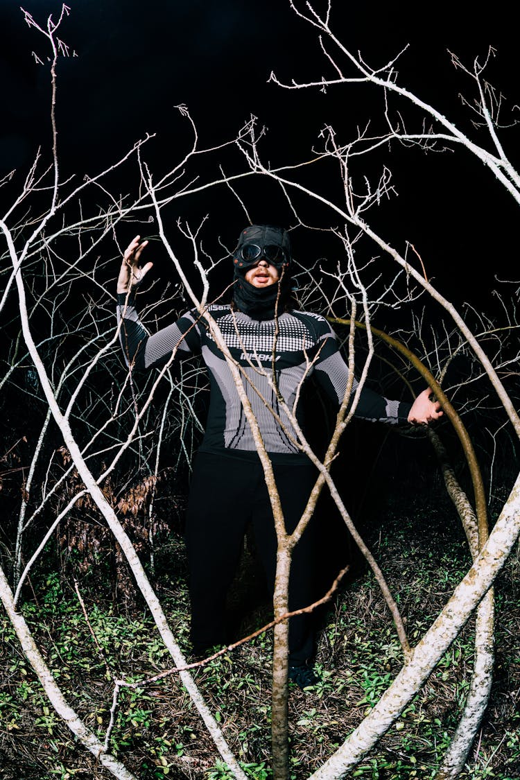 Man Posing Among Branches At Night