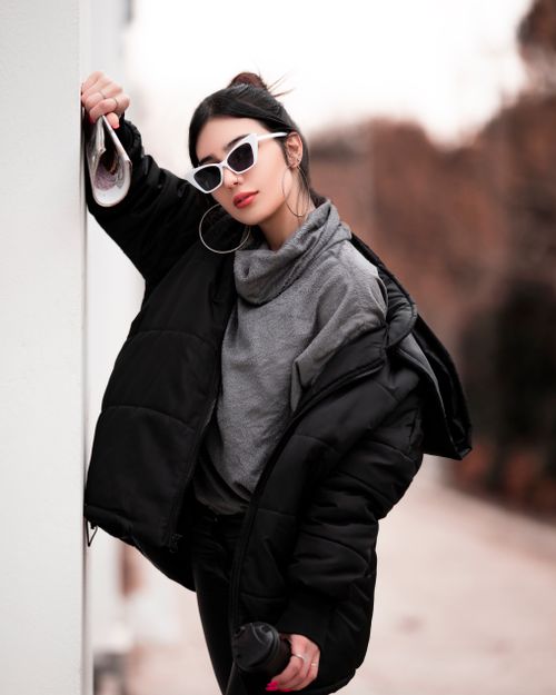 Free Fashionable woman in black jacket posing outdoors with sunglasses and red lipstick. Stock Photo
