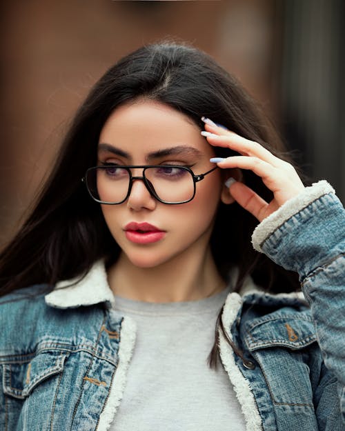 Young Woman in Denim Jacket Wearing Black Framed Eyeglasses and Red Lipstick