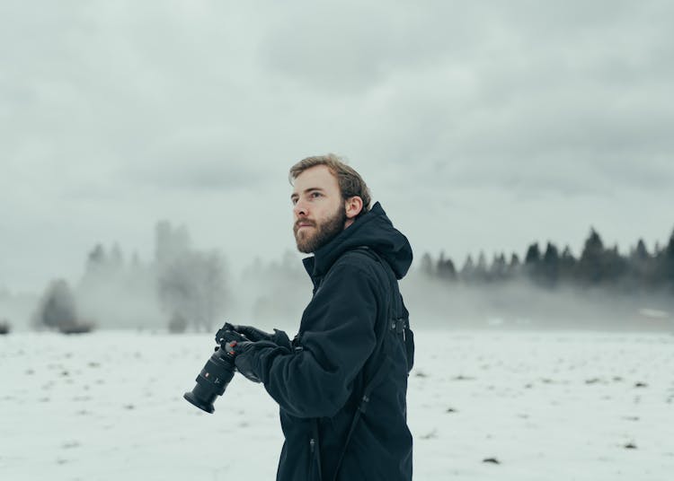 Man With Professional Camera In Winter Nature