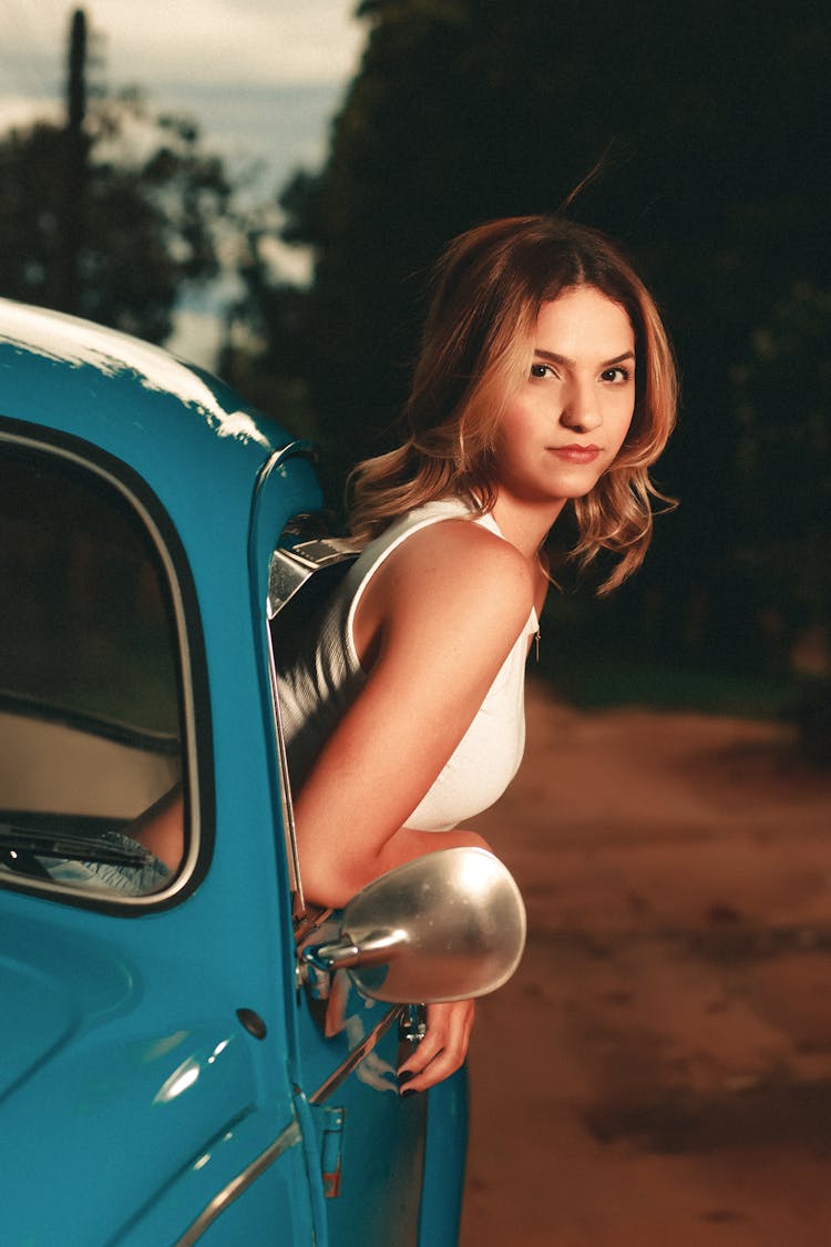 Young Woman Hanging Out Of A Car