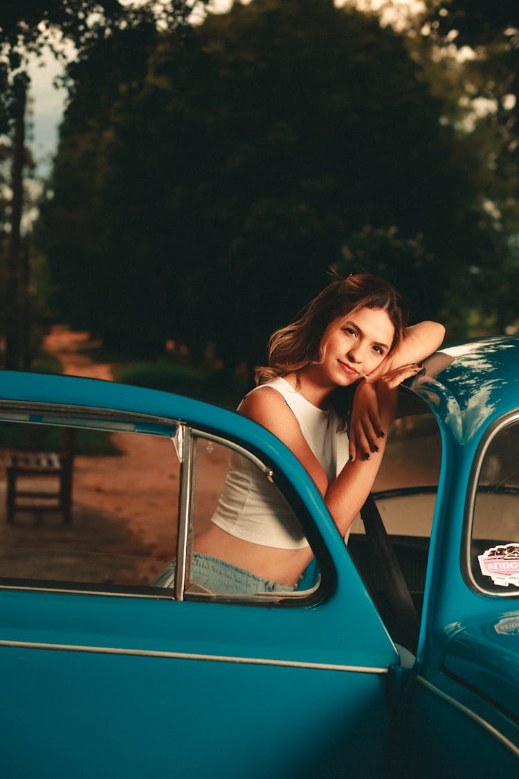 A Woman Leaning On Blue Car