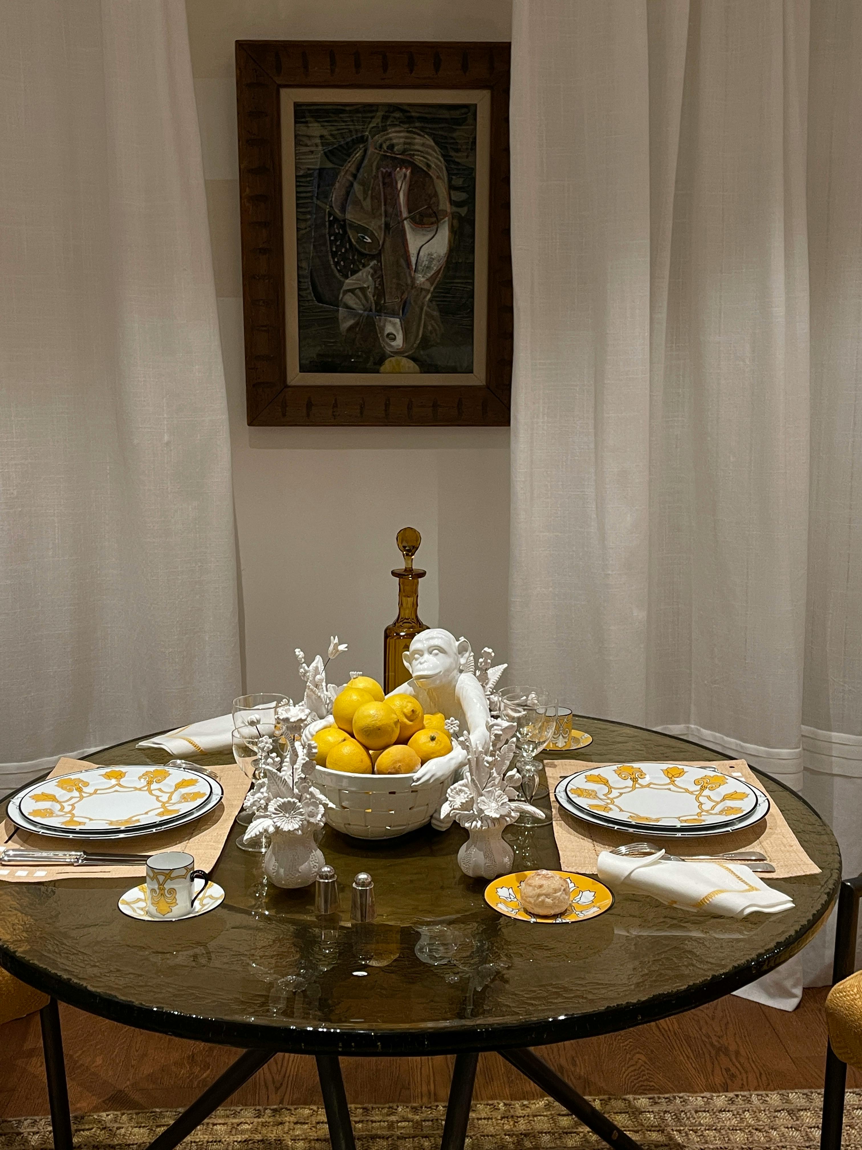 Chic round dining table setup with lemons centerpiece, elegant decor.