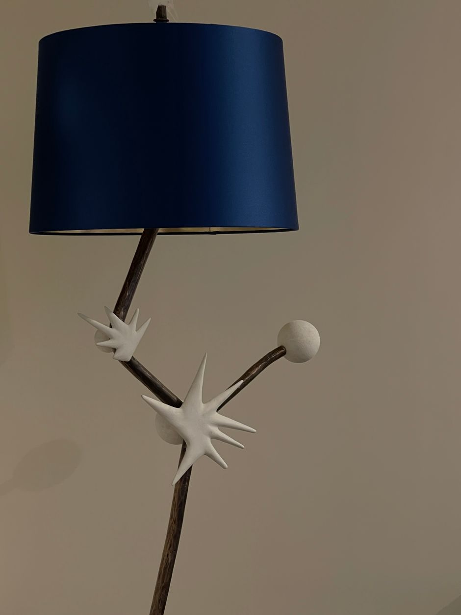 Stylish artistic lamp with a unique design and a blue shade.
