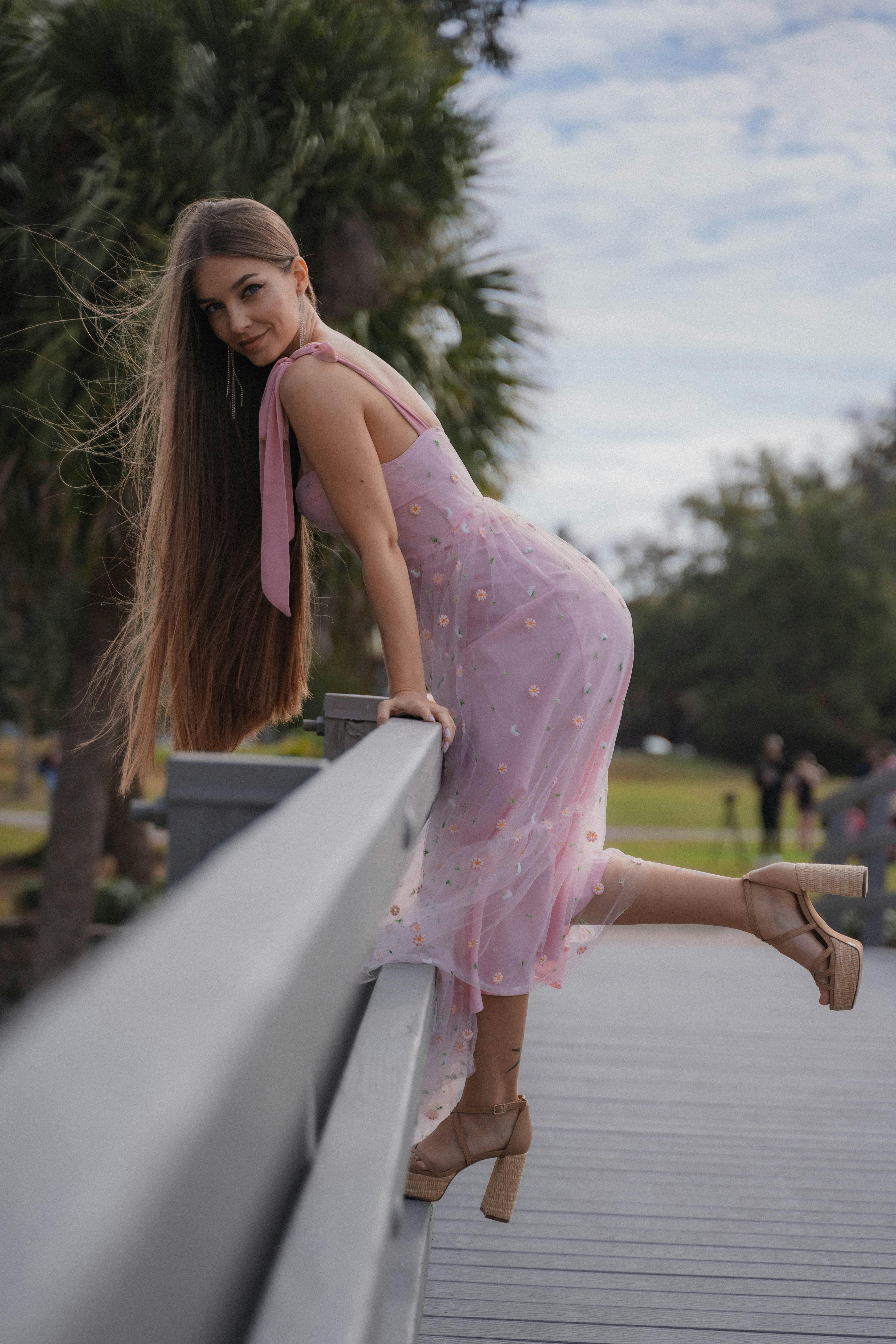 Free A woman gracefully poses in a flowing pink dress on a sunny day in Winter Park, FL. Stock Photo