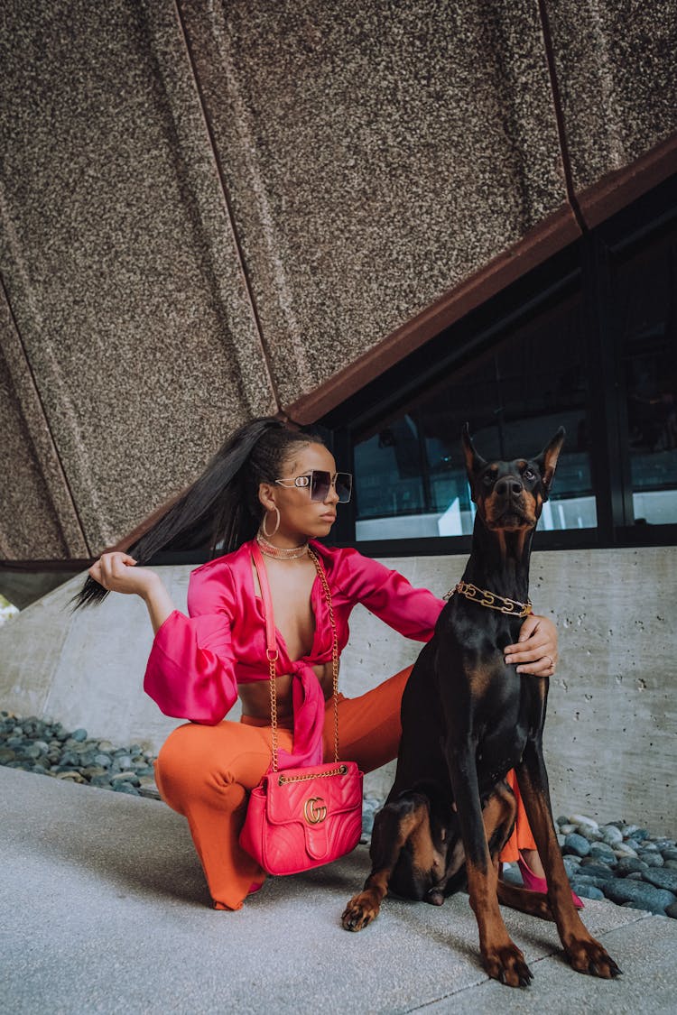 A Woman Sitting With Her Dobermann Dog