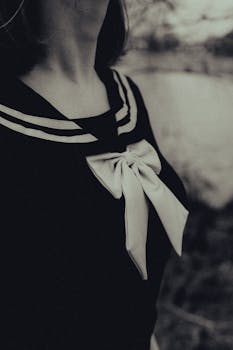 Artistic black and white photo of sailor outfit with bow, perfect for fashion themes.