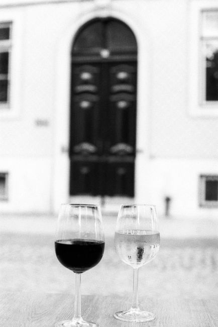 Artistic black and white photo of wine glasses outdoors in Lisbon.