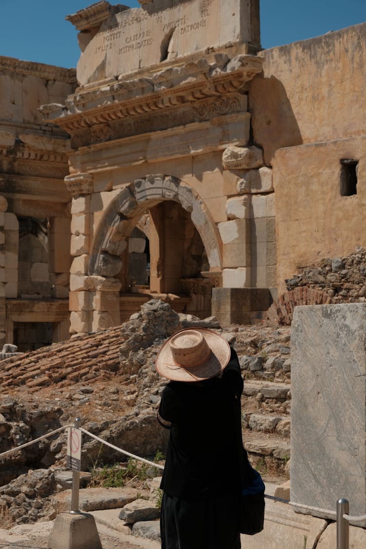 A Person Wearing Sombrero Standing Near An Old Abandoned Castle