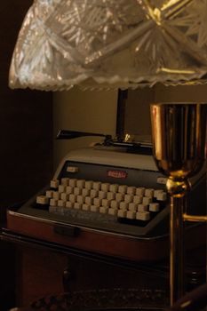 A cozy scene featuring a vintage typewriter under a warmly lit antique lamp, evoking a sense of nostalgia.