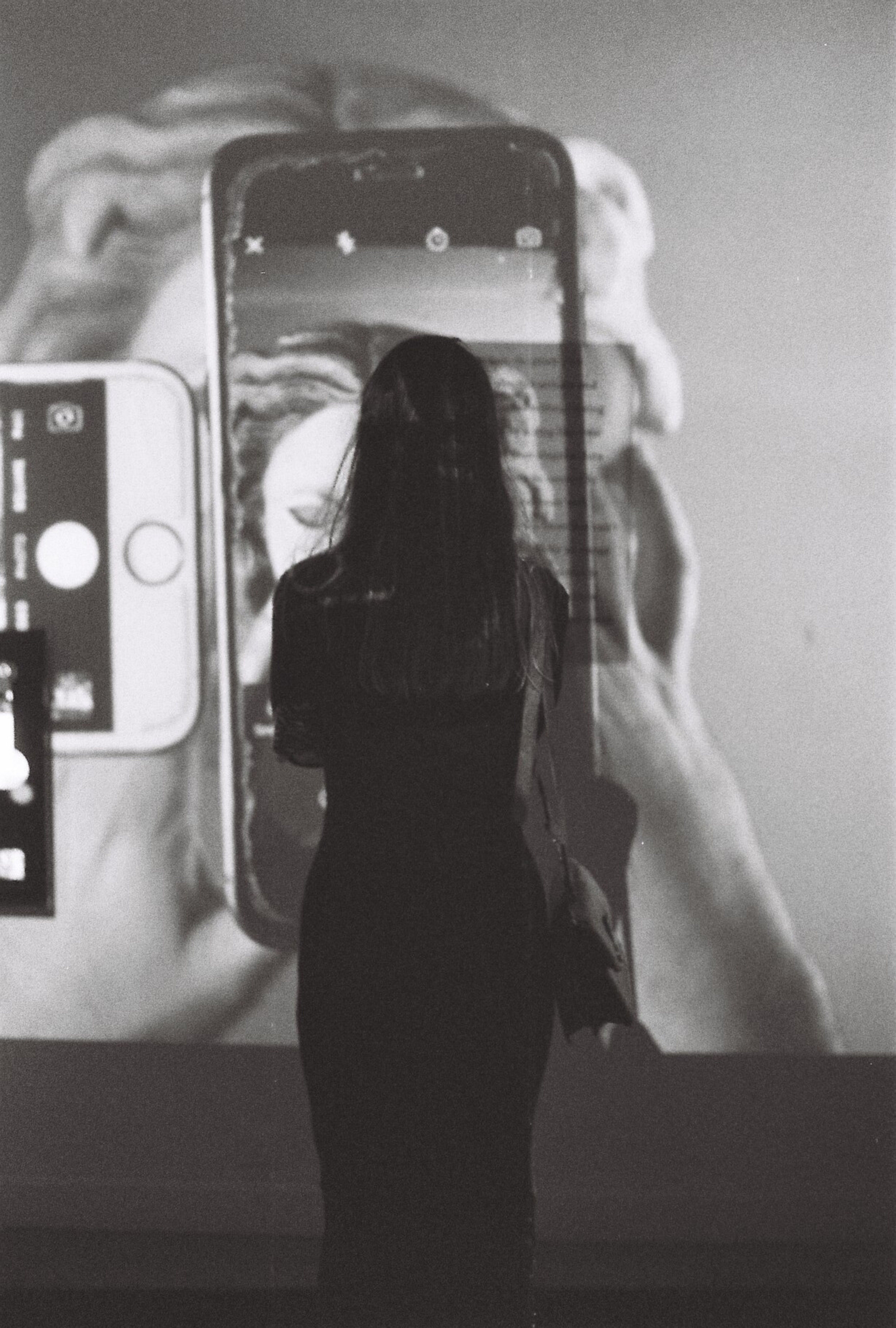 A silhouette of a woman watching a smartphone projection in Istanbul.