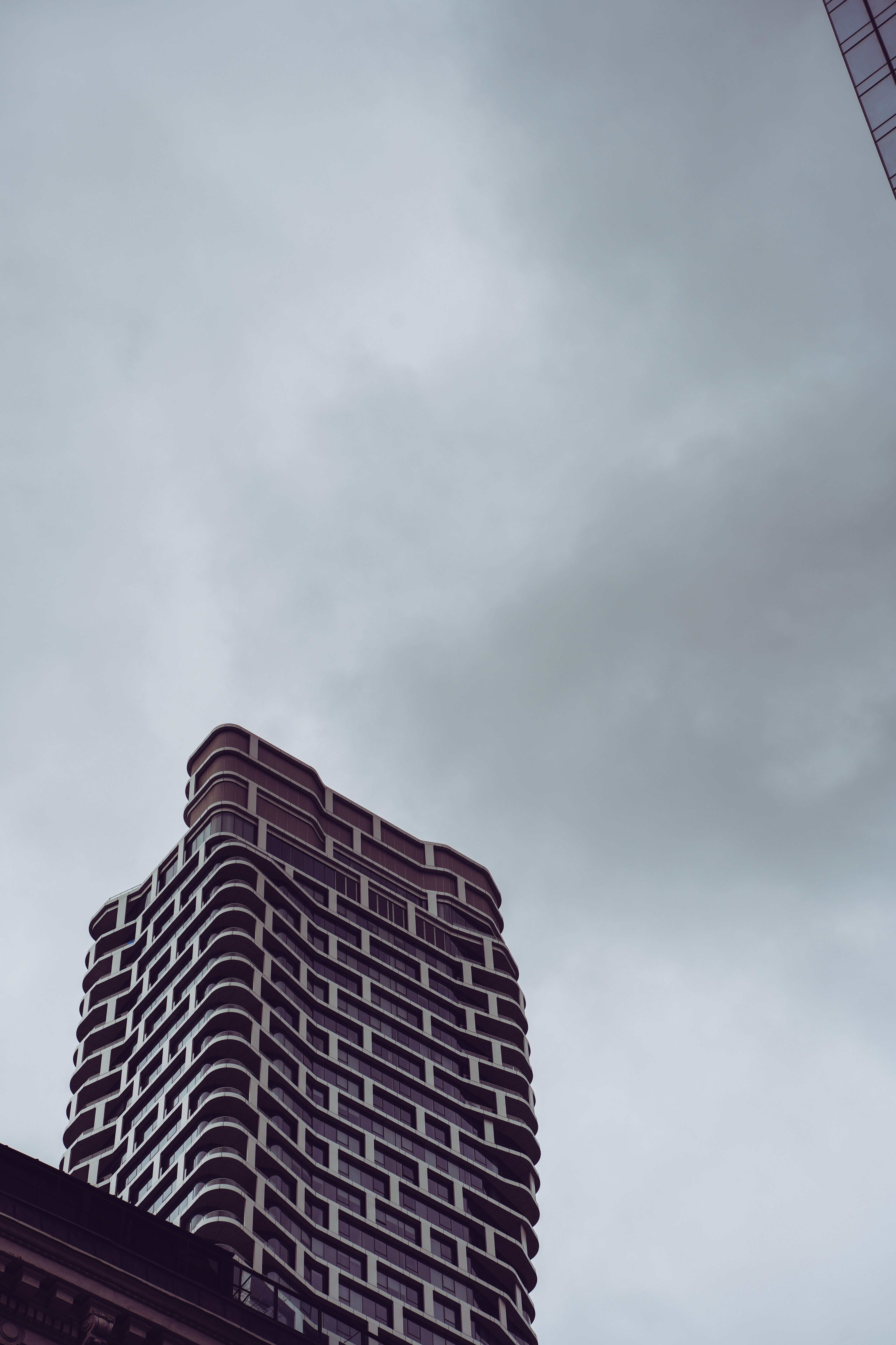 Low-Angle Shot of a Modern Building under the Cloudy Sky · Free Stock Photo
