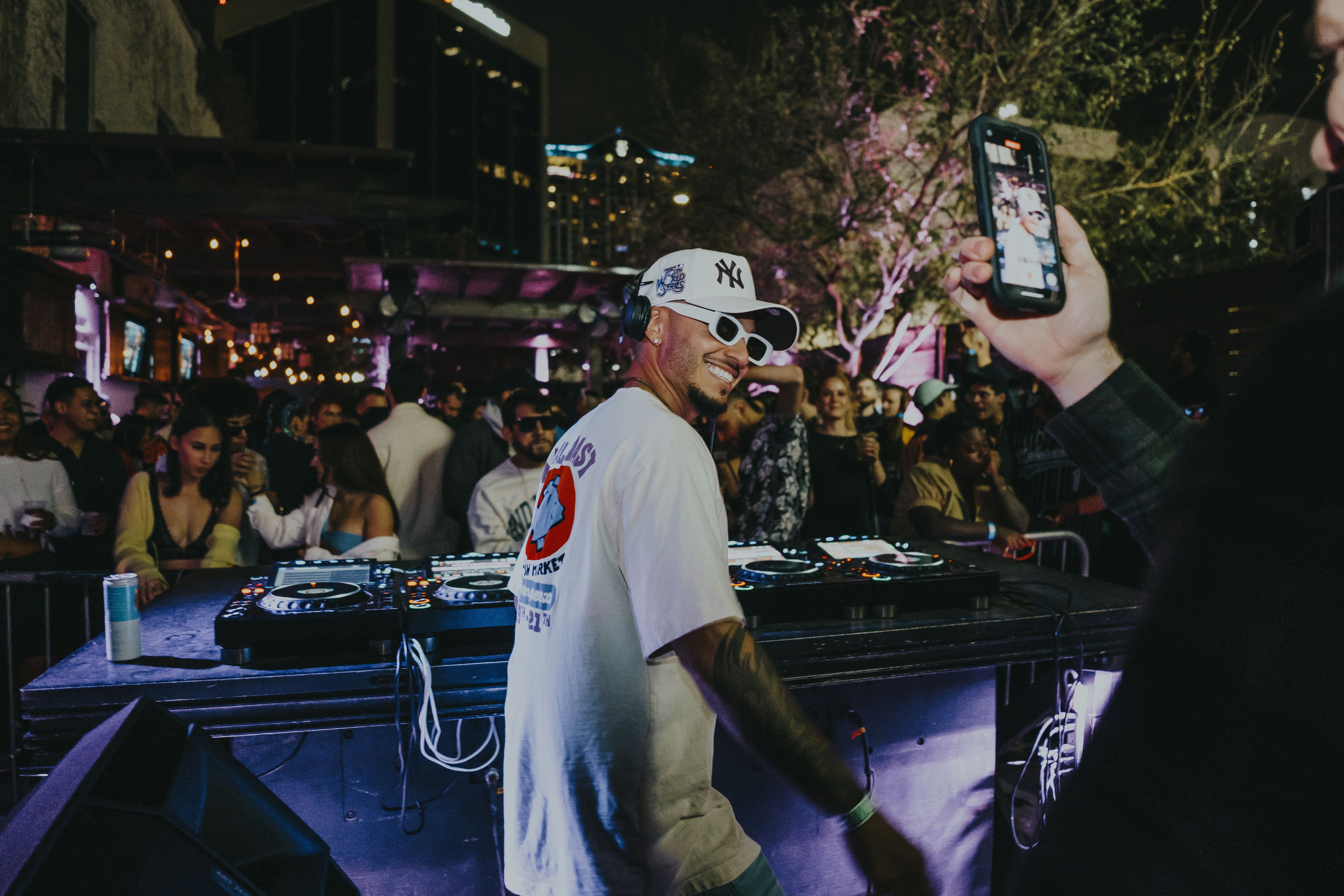 MLB photo featuring DJ spinning music at a lively nightclub with partygoers enjoying the night.