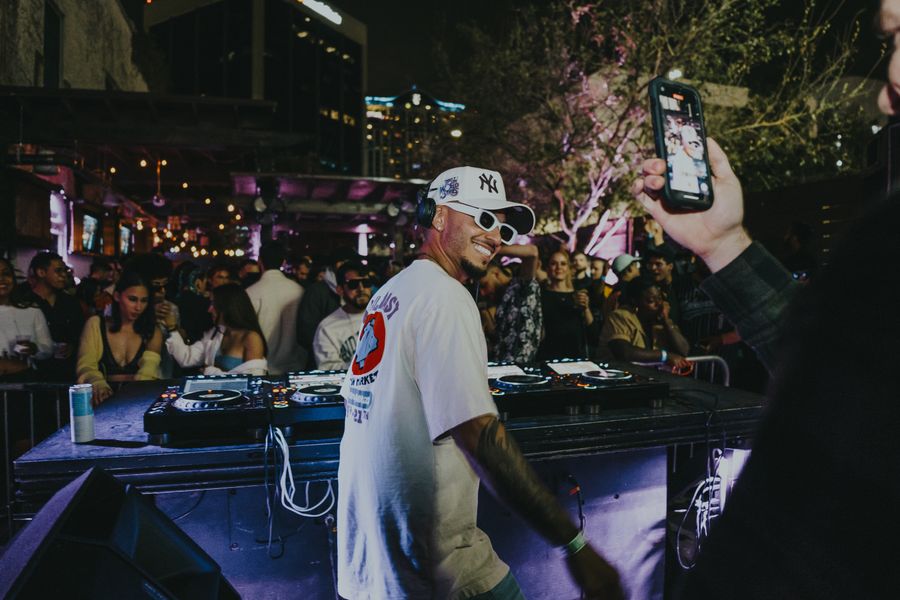 DJ in sunglasses playing a set at a club party