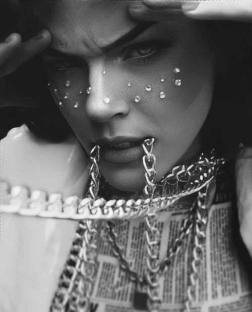 Close-up of Woman with Chain Jewelry and Crystals on Face
