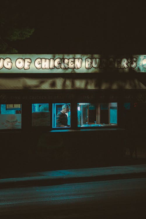 Person Working in Diner near Road at Night