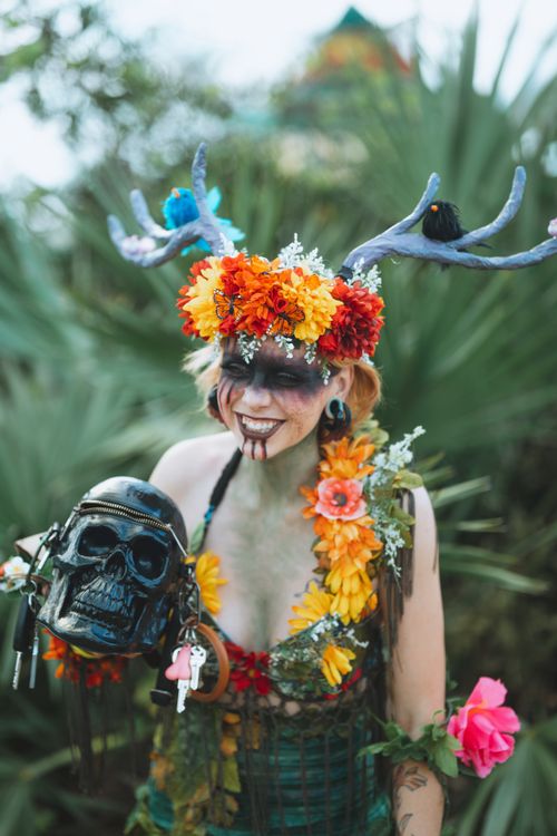 Free A person adorned with a floral headpiece and holding a skull, set against a natural backdrop. Stock Photo