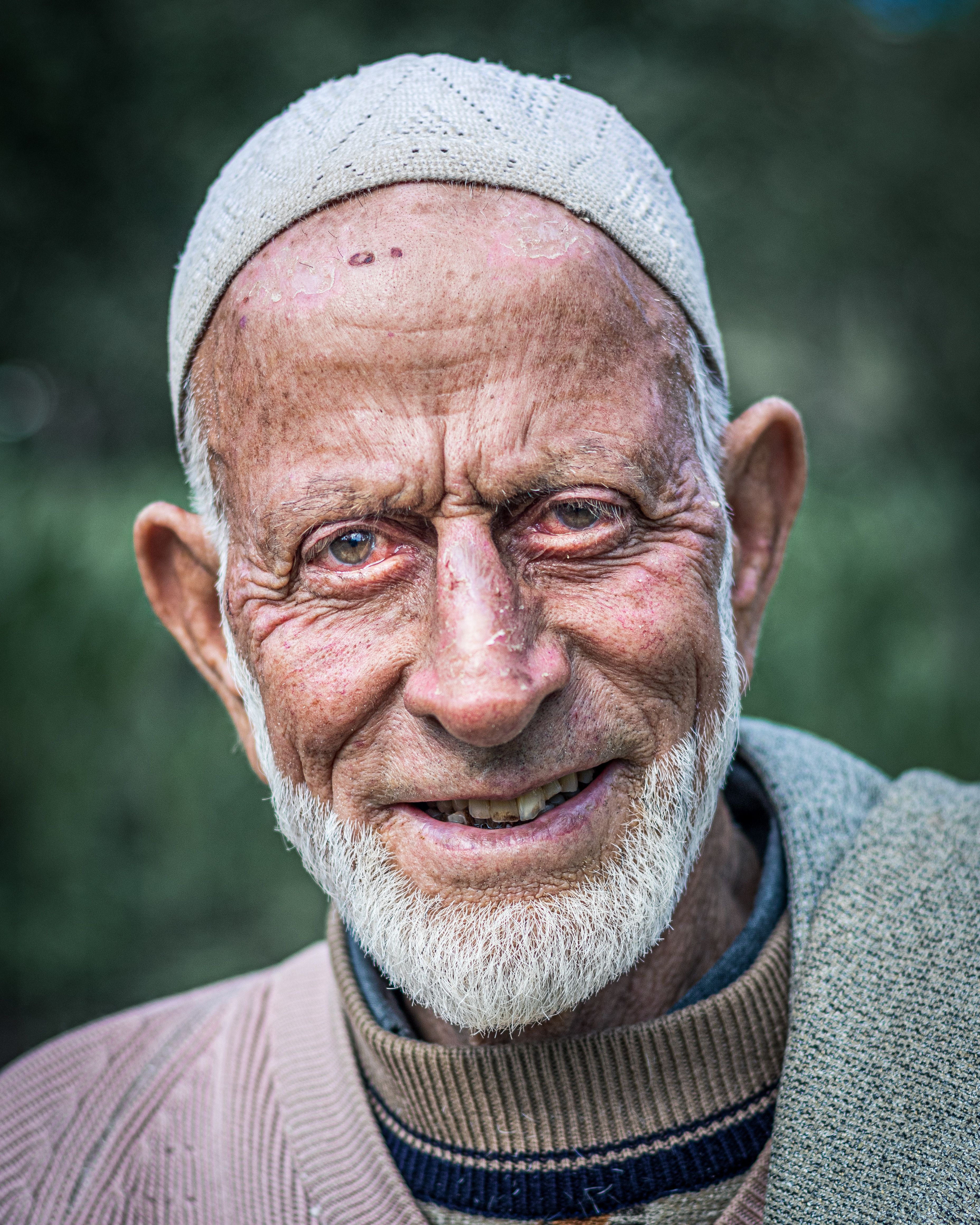 Portrait of a smiling elderly man with a white beard in Yousmarg.