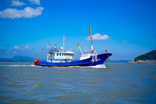 Free Fishing Boat Cruising the Sea Stock Photo