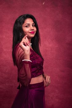 Beautiful portrait of a woman in Chennai wearing traditional attire against a red background.