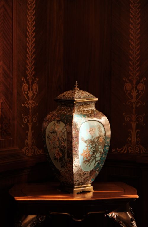 Free Ornate pottery vase with intricate floral patterns displayed elegantly on a wooden table indoors. Stock Photo
