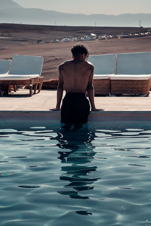Back View of a Topless Man on Pool 