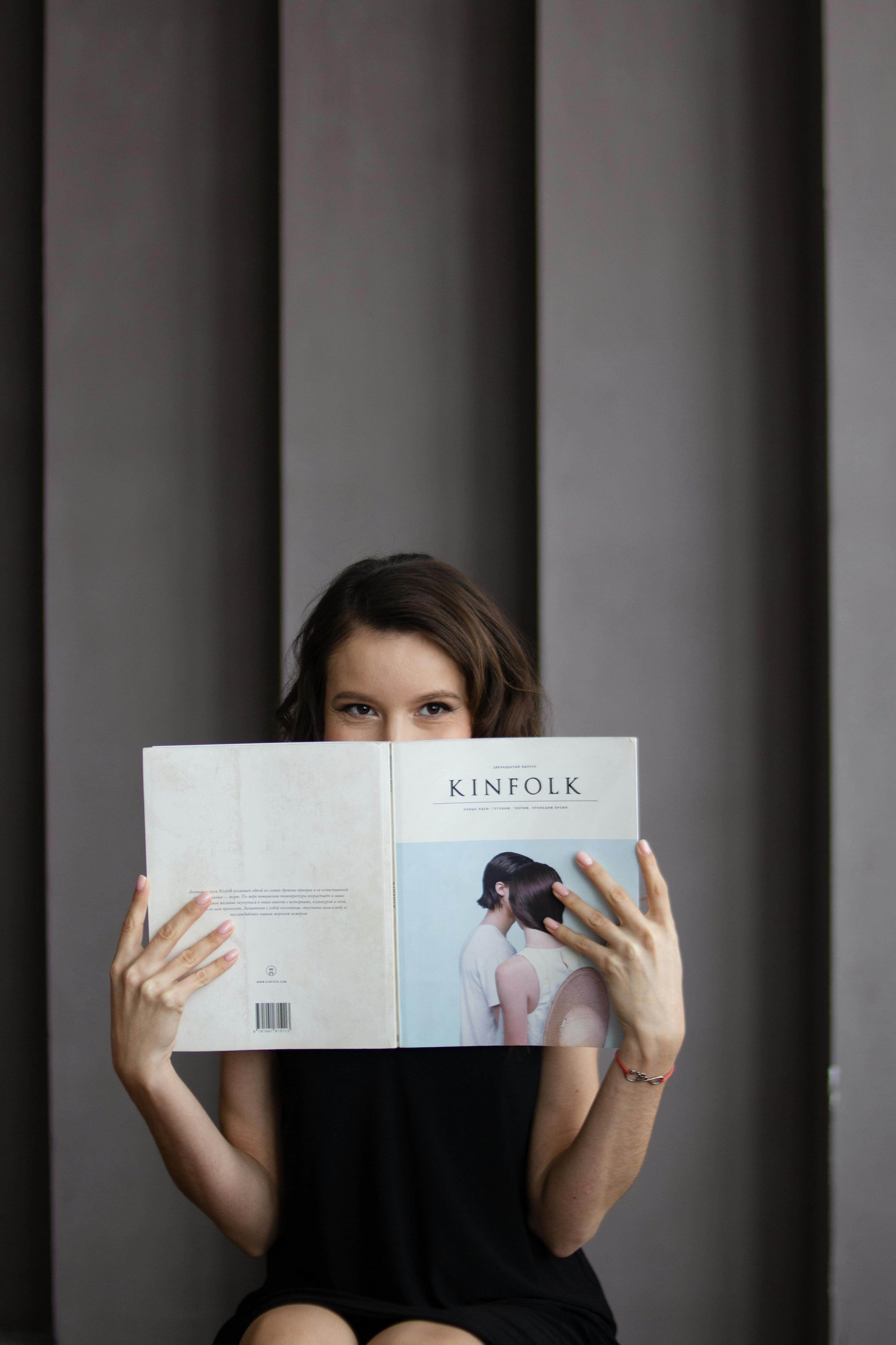 Woman Posing With Magazine On Grey Background · Free Stock Photo