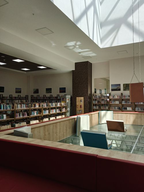 Free A well-lit modern library interior with bookshelves and a glass skylight. Stock Photo