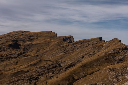 Free Breathtaking view of rugged mountain terrain under a partially cloudy blue sky. Stock Photo