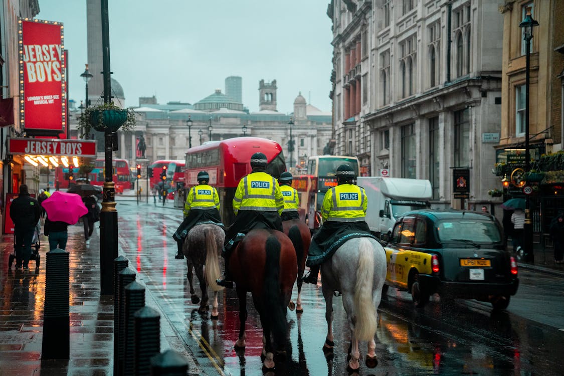 Back View of Police Officers on Horseback on a Busy Street in London, England, UK