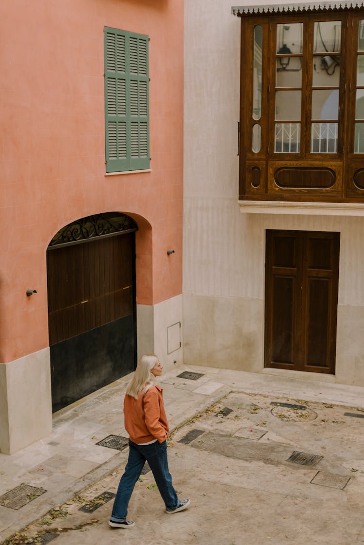 A Woman Walking On The Building Courtyard