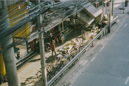 Free Aerial view of a bustling street market in Bangkok with bikes and vendors. Stock Photo