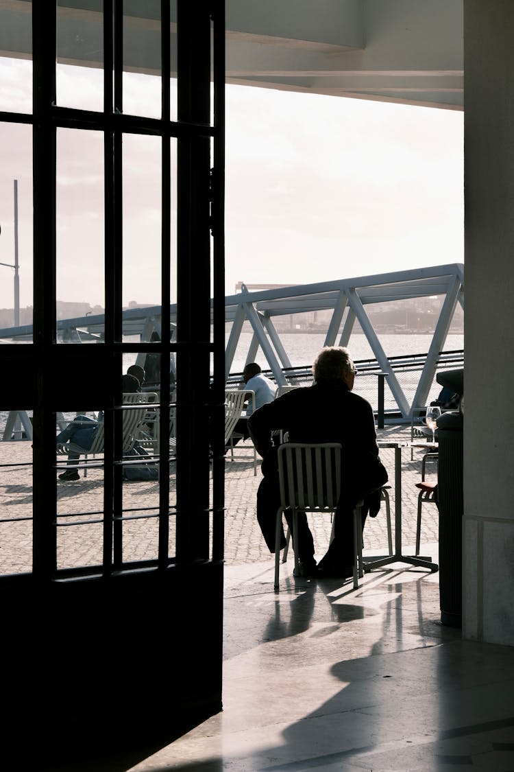 People Sitting At Outdoor Cafe Terrace Near Water