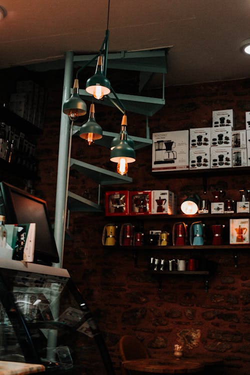Interior of Coffee Shop with Pendant Lamps and Display on Wooden Shelves 