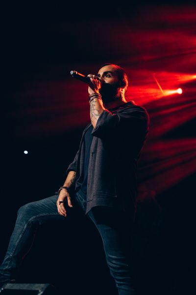 Cantante masculino actuando apasionadamente en un escenario