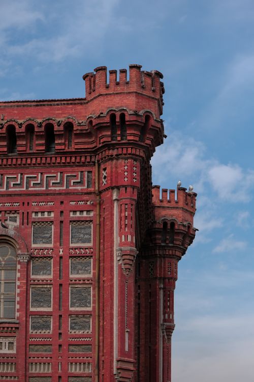 Free Detailed view of a historic red brick facade in Istanbul against a clear blue sky. Stock Photo