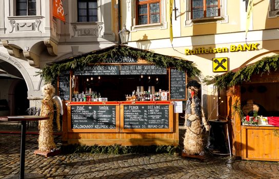 Charming Christmas market stand in an old town setting with festive decorations and traditional offerings.