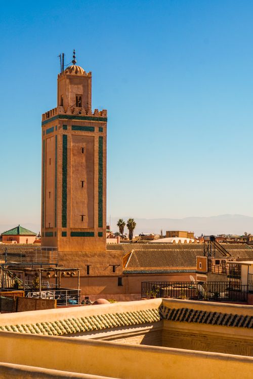 Free Stunning view of a traditional minaret amidst the vibrant rooftops of Marrakech, capturing the city's unique architectural charm. Stock Photo
