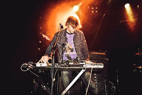 A man in a jacket playing a keyboard