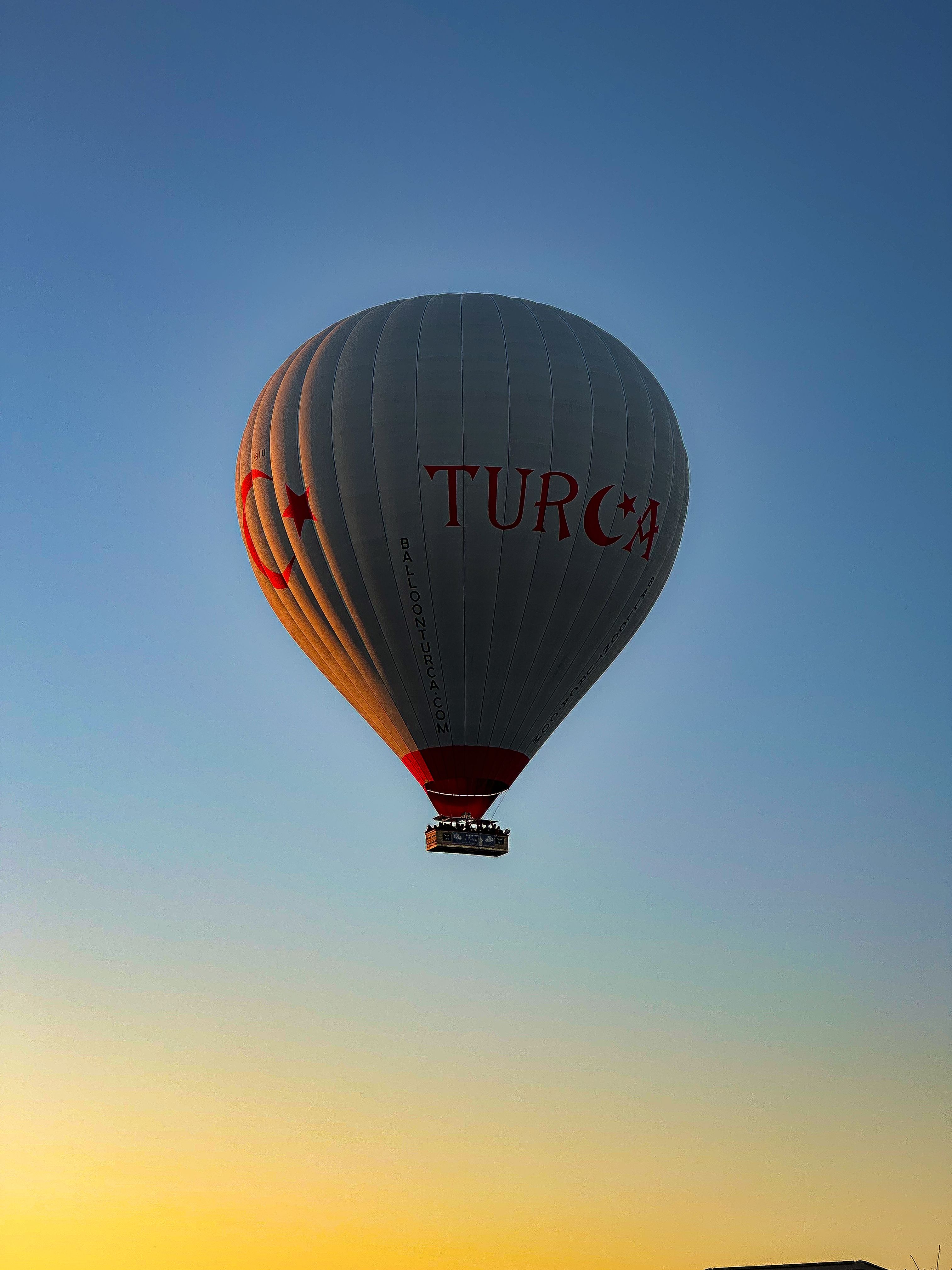 A hot air balloon flying over the sky at sunset · Free Stock Photo