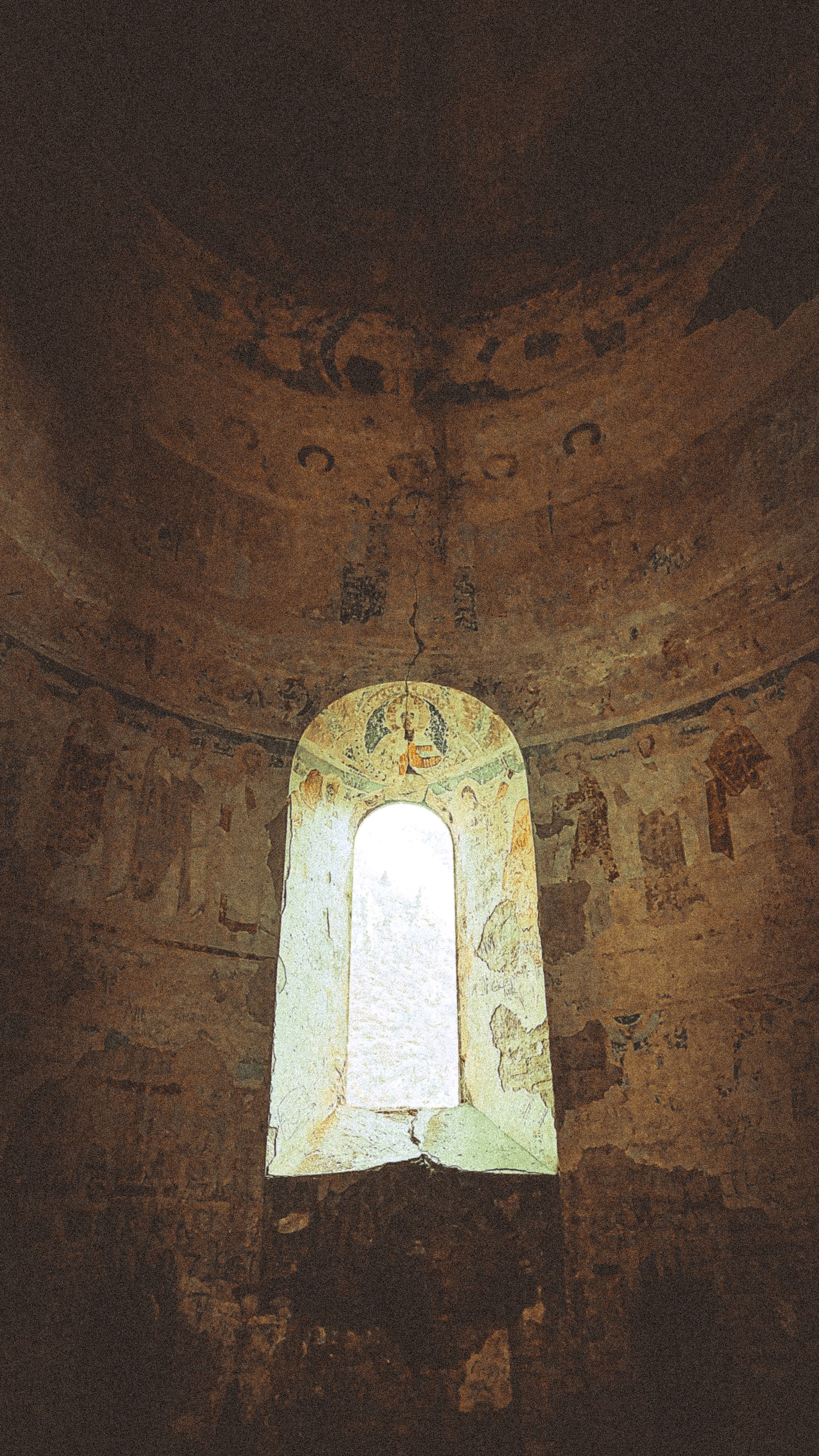 A mystical view of an ancient frescoed window in an old stone church.