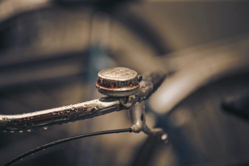 Free A close-up of a vintage bicycle bell with raindrops on a Paris street, evoking nostalgia. Stock Photo