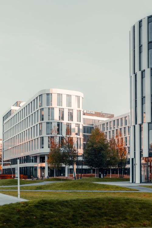 Free Contemporary office buildings with green lawns in a city at sunset. Stock Photo
