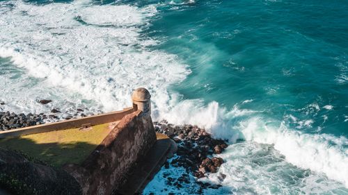 Free Aerial view of a stone fortress by the ocean with waves crashing against the seashore. Stock Photo