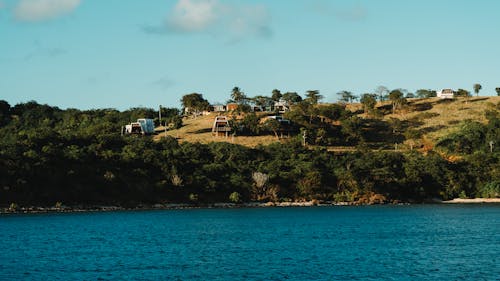 Photo of the Coastline with Buildings on the Hill 